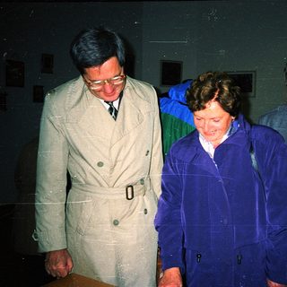 Four people walking indoors during nighttime event.
