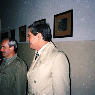 Three people conversing indoors at an event.