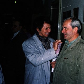 Three people conversing indoors at an event.