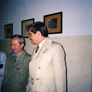 Three individuals standing indoors during an event.