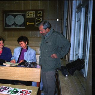 People examining documents at a table in dimly lit room.