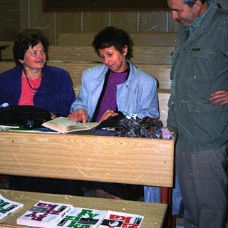 People examining documents at a table in dimly lit room.