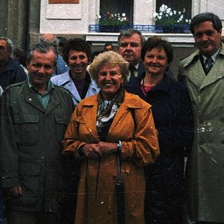 Group posing outside building with Ukrainian flags.