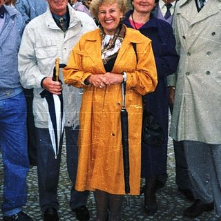 Group of people posing outdoors near a building.