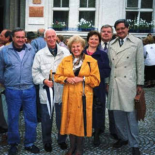 Group of people posing outdoors near a building.