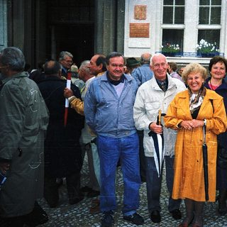 Group of people posing outdoors near a building.