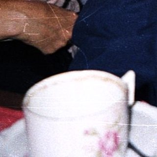 Three people sitting indoors, likely having a casual conversation.