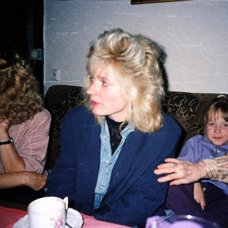 Three people sitting indoors, likely having a casual conversation.