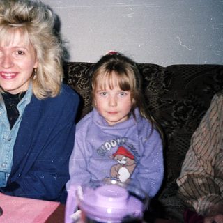 Three women sitting indoors, smiling at camera.