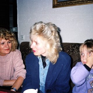 Three women sitting together indoors, mid-conversation.