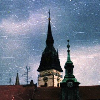 Historic European cityscape at night with church spires.