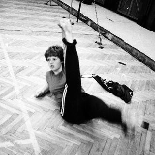 Child practicing gymnastics on balance beam.