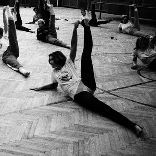 Group practicing yoga or stretching in gymnasium.