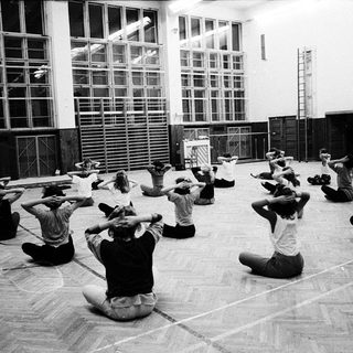 Group practicing yoga or stretching exercises indoors.