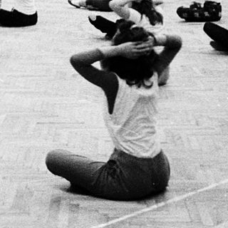 Group practicing yoga or stretching exercises indoors.