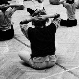 Group practicing yoga or stretching exercises indoors.