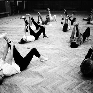 Group performing floor exercises in dance studio.