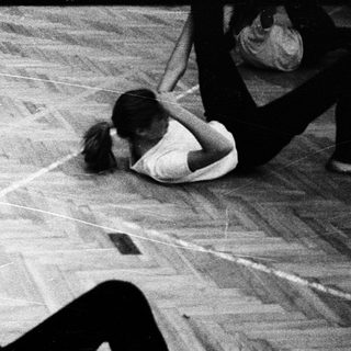 Person performing a dance move on wooden floor.