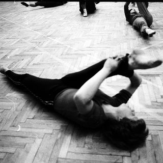 Person performing dynamic floor exercise in indoor setting.