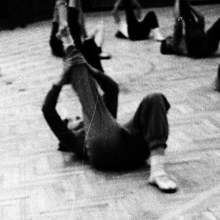 Group fitness class performing floor exercises.