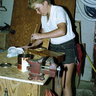 Young person using hand tools in a workshop.