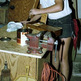 Young person using hand tools in a workshop.