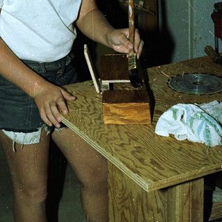 Young man using hand plane on wooden board.
