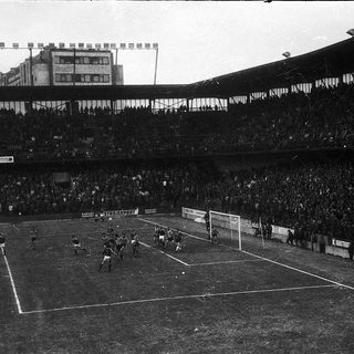 Black-and-white soccer match with packed stadium.