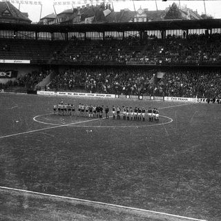 Pre-match team formation on a large stadium pitch.