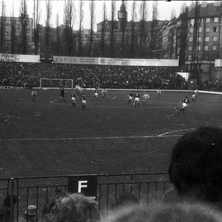 Historical soccer match with large crowd.