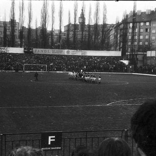 Historical football match with large crowd.