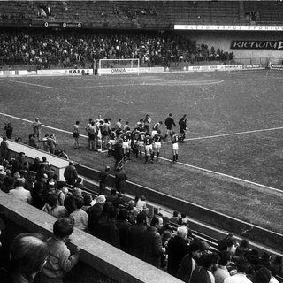 Football match pre-game team walkout in stadium.