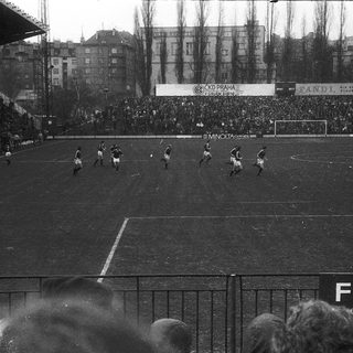 Black-and-white soccer match in crowded stadium.