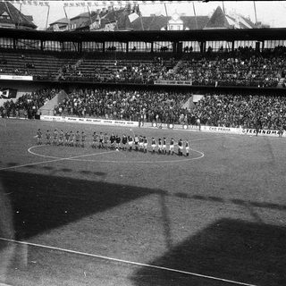 Pre-war football match with full stadium.