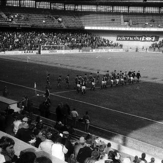 Pre-match football team warm-up on stadium pitch.