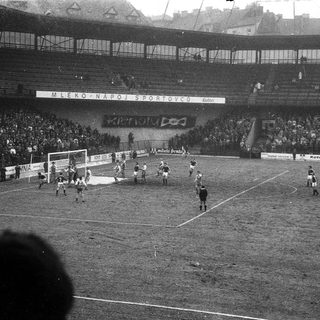 Black-and-white soccer match in crowded stadium.