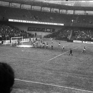 Black-and-white soccer match in crowded stadium.