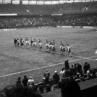 Classic football match pre-kickoff at packed stadium.