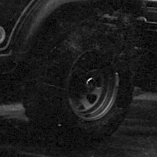 Traffic jam with vintage Jeeps and cars in wet urban area.
