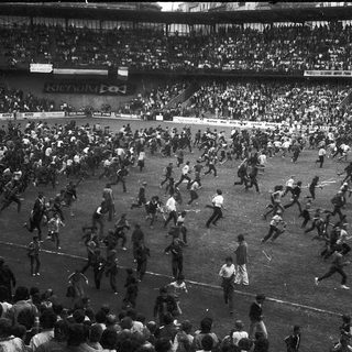 Chaotic stadium riot during match.