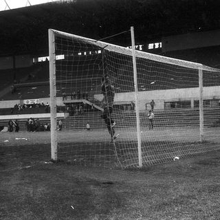 Empty stadium with collapsed soccer goal net.