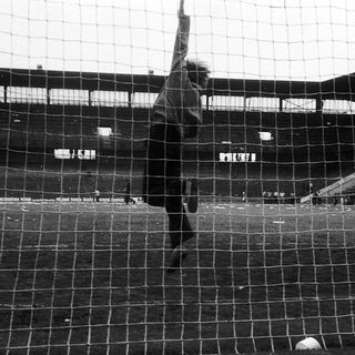 Goalkeeper diving to catch a ball.