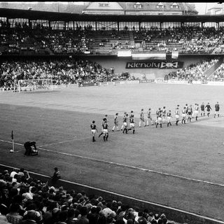 Pre-match team walkout on soccer field.