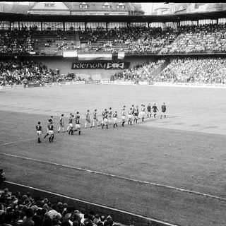Pre-match team walkout on soccer field.