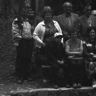 Group of people posing outdoors in vintage clothing.