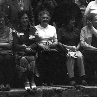 Group of people posing outdoors in vintage clothing.