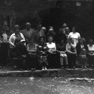 Group of people posing outdoors in vintage clothing.