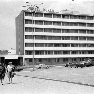Mid-century Hotel Dukla building with vintage cars and pedestrians.