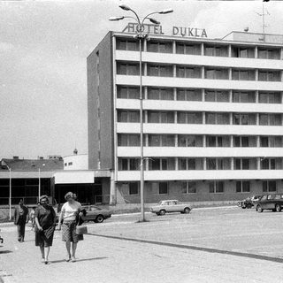 Mid-century Hotel Dukla building with vintage cars and pedestrians.