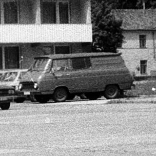 Mid-century Hotel Dukla building with vintage cars and pedestrians.